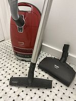 Full view of red canister vacuum with telescoping wand, hard floor nozzle and black Electro Comfort power head