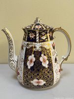 Full front view of coffee pot showing overall shape, color palette and pattern