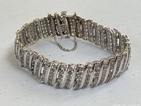 Front view of bracelet showing wavy link design and pave diamonds