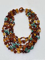 Full view of multi-strand necklace laid out showing overall shape and variety of beads.