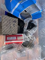 Box containing assorted bike sprockets and gears in packaging and bubble wrap