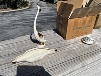 Photo showing white ceramic bird figurine with gold accents, leaf-shaped ceramic dish with gold accents, two cardboard boxes marked Yankee Candle and #OptOutside, and a fine china teacup and saucer with floral design.