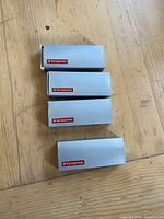 Four Victorinox-branded grey boxes arranged vertically on wooden surface