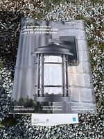 Front of packaging showing LED Outdoor Lantern in burnished bronze finish with clear hammered glass, suitable for outdoor use.