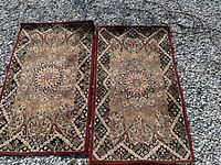 Two Persian style rugs laid side by side on gravel, showing full view of both rugs with detailed patterns and colors.