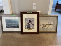 Three framed Robert Bateman prints standing against a wall, showing varied frame styles and nature themes