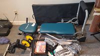 Photo showing overall Easy Shape Pro exercise bench and pedaler with assorted fitness accessories grouped beside bench on carpet