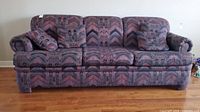 Front view of Sealy three-seater sofa with patterned multi-color upholstery and matching cushions.
