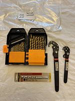 Open case showing 26 gold-colored Titanium Nitride drill bits of various sizes and two black Talan wrenches