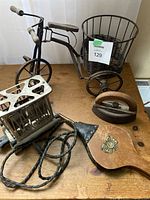 Overview of the antique and vintage lot items including toaster, bellows, iron and miniature bicycle cart.