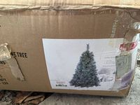 Box showing label with image of lit Christmas tree, confirming tree type and size.
