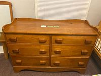 Full front view of vintage solid wood dresser with six drawers and wooden handles, showing the top surface and drawer arrangement.