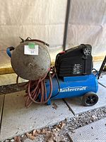 Mastercraft air compressor with attached spare holding tank and hoses visible.