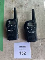 Pair of Midland Xtra Talk walkie talkies side by side on a surface, showing front button layout and antenna