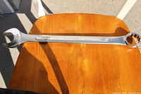 1-1/2 inch Truecraft combination wrench on wooden chair, showing branding and size markings clearly.