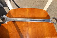 Full view of a 1-3/8 inch Truecraft combination wrench placed on a wooden surface, showing both open and box ends.