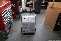 Front view of Schumacher 40/160 Auto Battery Charger showing meters, wiring diagram, power switch, and cables on top.