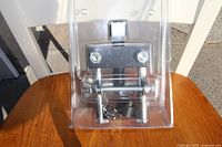 Front view of heavy duty puller tool sealed in clear plastic packaging on wooden surface.