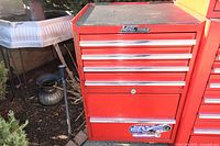 Front view of red 5-drawer tool chest showing Mac Tools logo plate, drawer pulls, lock cylinder and top rubber mat.