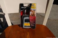 Master Safe Lock Box in its original packaging, black lock box with combination lock showing, packaged on cardboard backing with branding and usage information.