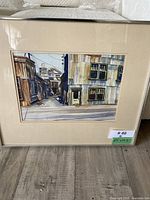 Framed and matted original watercolour painting showing street scene from Granville Island with buildings and perspective view.