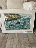 Framed watercolour painting of lily pads and pink flowers in a pond, showing the entire artwork and frame.