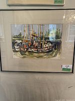 Framed watercolour painting showing the entire artwork and frame, hung on a wall with visible reflection on the glass.