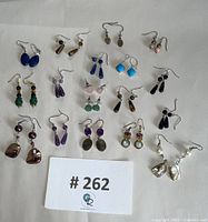 All 18 pairs of assorted natural stone earrings arranged on white background, showing color and style variety.