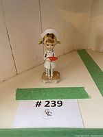 Full view of vintage Gorham Moppets nurse figurine standing on a hexagonal base.