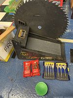 Full view of the Pivit folding ladder tool, Milwaukee RED HELIX drill bit set, two cases of Erwin wood spade bits, large decorative saw blade visible, Turtle Wax container partly visible.