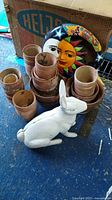 Overview photo showing white rabbit door stop, stacked terracotta pots, and colorful moon and sun decoration.