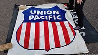 Union Pacific wall banner displayed on ground, showing blue shield logo with red and white stripes.