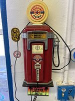 Front view of vintage red gasoline pump styled wall phone with gasoline highway emblem and detailed gas meter display.