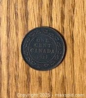 Reverse side of the 1917 Canadian Large Penny showing 'ONE CENT CANADA 1917' and surrounding wreath on wooden surface.