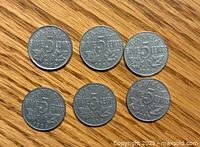 Six 1936 Canadian nickel coins arranged in two rows on a wooden surface showing the reverse side with the denomination and date.