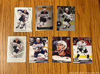 Front view of 7 Connor McDavid hockey cards showing various designs and player images.
