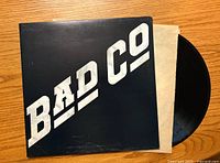 Front of the Bad Company vinyl album cover with bold white logo on black background and partially visible record sleeve.