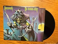 Front view of vinyl album cover 'No Mean City' by Nazareth featuring a skeletal warrior character in armor holding weapons.