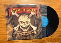Front cover of Copperhead Road vinyl album by Steve Earle, showing skull and crossbones design with artist name and album title.