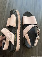 Side and bottom view of baby pink leather Dr. Martens platform sandal showing the chunky sole and straps.