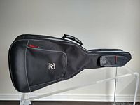 Full side view of black Profile soft acoustic guitar case showing overall shape, stitching, and handle