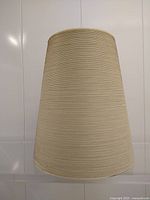 Front view of beige fiberglass lampshade showing horizontal string texture