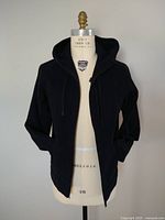 Front view of the black Lululemon men's hoodie on a dress form, showing zippered front and hood.