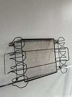 Angled side view of the tray highlighting the metal wire construction and the twisted wire handle detail on one side.