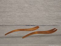 Pair of bent wood salad tossers displayed side by side, showing curved shape and polished finish.