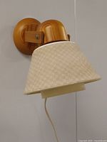 Side view of wall sconce showing pine wood construction, fabric shade, and wall mount.