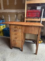 Full view of old wooden work desk showing drawers, legs and overall shape.