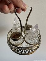 Top angle image showing the round silver caddy with two glass large shakers with silver tops and two smaller glass bottles with plastic tops.