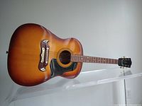 Full front view showing body shape, sunburst finish and pickguard