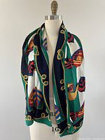 Full view of vintage silk scarf draped on a dress form showing boat and rope pattern with dominant colors of green, navy blue, white, red, and yellow.